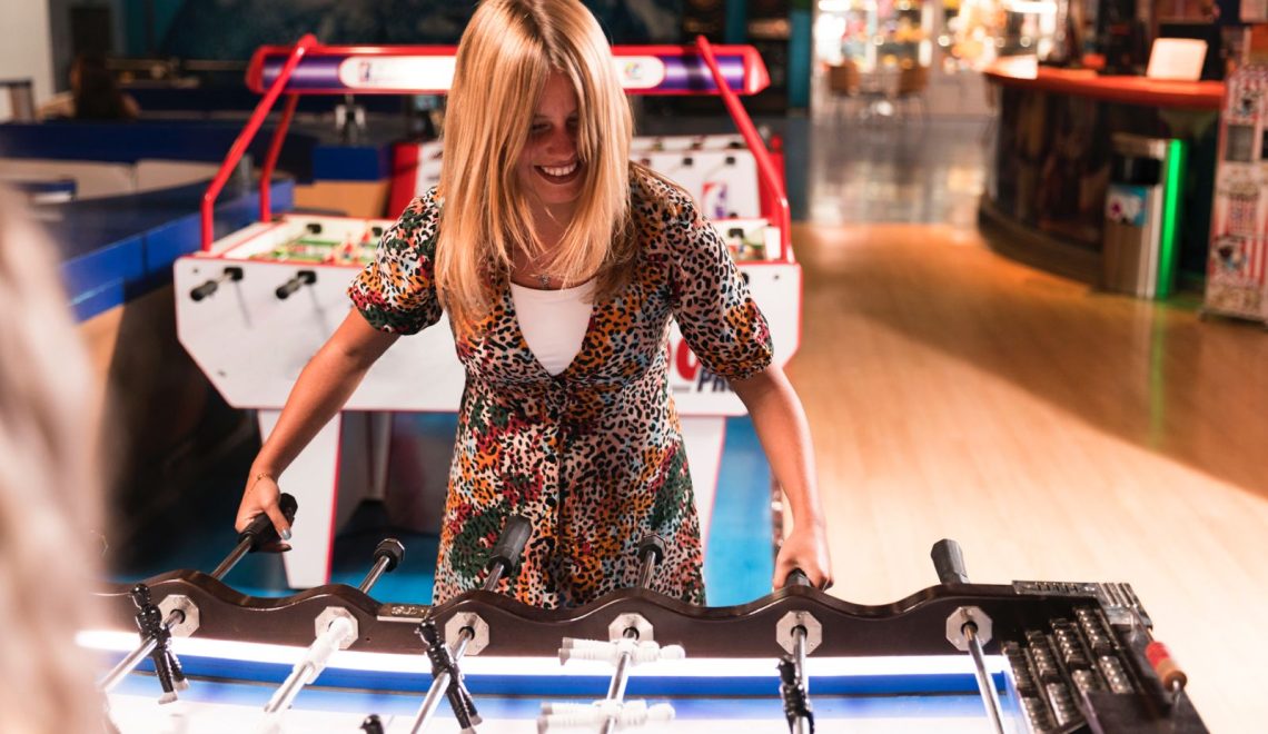 mujer jugando en un arcade